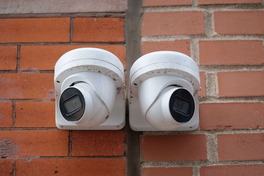 Two dome cameras on a brick wall